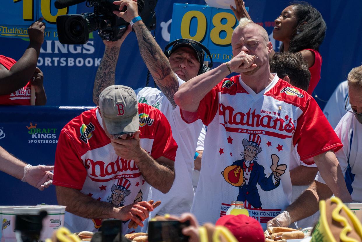 Competitive eaters Geoffrey Esper (L), second-place winner, and Nick Wehry (R), third-place winner, participate in the 2021 Nathan's Famous 4th Of July International Hot Dog Eating Contest on July 4, 2021, in New York City.