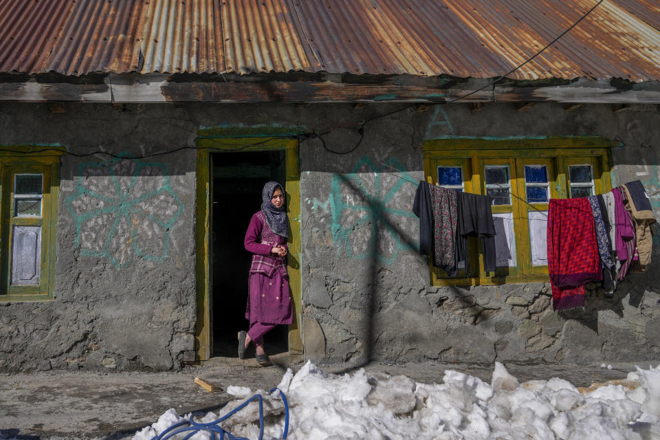 Kashmiri village girl Tanveera Banoo stands at the entrance of her house after receiving the vaccine for COVID-19 during a COVID-19 vaccination drive in Gagangeer, northeast of Srinagar, Indian controlled Kashmir, Jan. 12, 2022. (AP Photo/Dar Yasin)