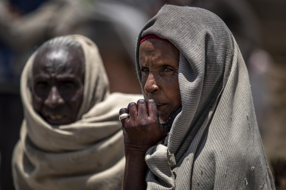 FILE - In this Saturday, May 8, 2021, file photo, a woman waits to receive foodstuffs such as wheat, yellow split peas and vegetable oil at a food distribution operated by the Relief Society of Tigray in the town of Agula, in the Tigray region of northern Ethiopia. The U.N. humanitarian chief warned Friday, June 4, 2021, that famine is imminent in Ethiopia's embattled Tigray region and the country's north and there is a risk that hundreds of thousands of people or more will die. (AP Photo/Ben Curtis, File)