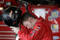 FILE - In this Feb. 18, 2006, file photo, Dale Earnhardt Jr., puts on his helmet and protective HANS device during preparations the day before the Daytona 500 auto race at Daytona International Speedway in Daytona Beach, Fla. NASCAR mandated the use of head-and-neck restraints in late 2001. Drivers had resisted using the U-shaped neck restraint made of carbon fiber because they found it cumbersome and restrictive. They became required equipment after 25-year-old Blaise Alexander was killed in a crash at Charlotte Motor Speedway some eight months after Earnhardt's death.(AP Photo/Chris O'Meara, File)