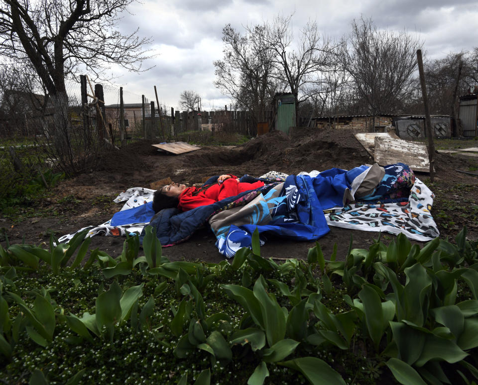 The body of Marina Naumec lies on a blanket after being exhumed from a backyard in Bucha.