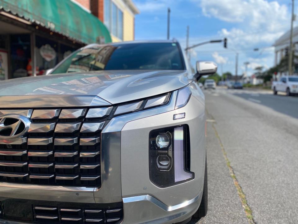 A close-up shot of a silver 2024 Hyundai Palisade SUV's front grille's driver's side.