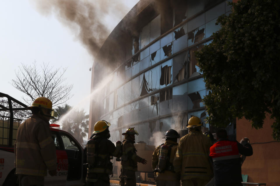 Firefighters work to put out a fire at the municipal government palace set by rural teachers' college students protesting the previous month's shooting of one of their classmates during a confrontation with police, in Chilpancingo, Mexico, Monday, April 8, 2024. (AP Photo/Alejandrino Gonzalez)