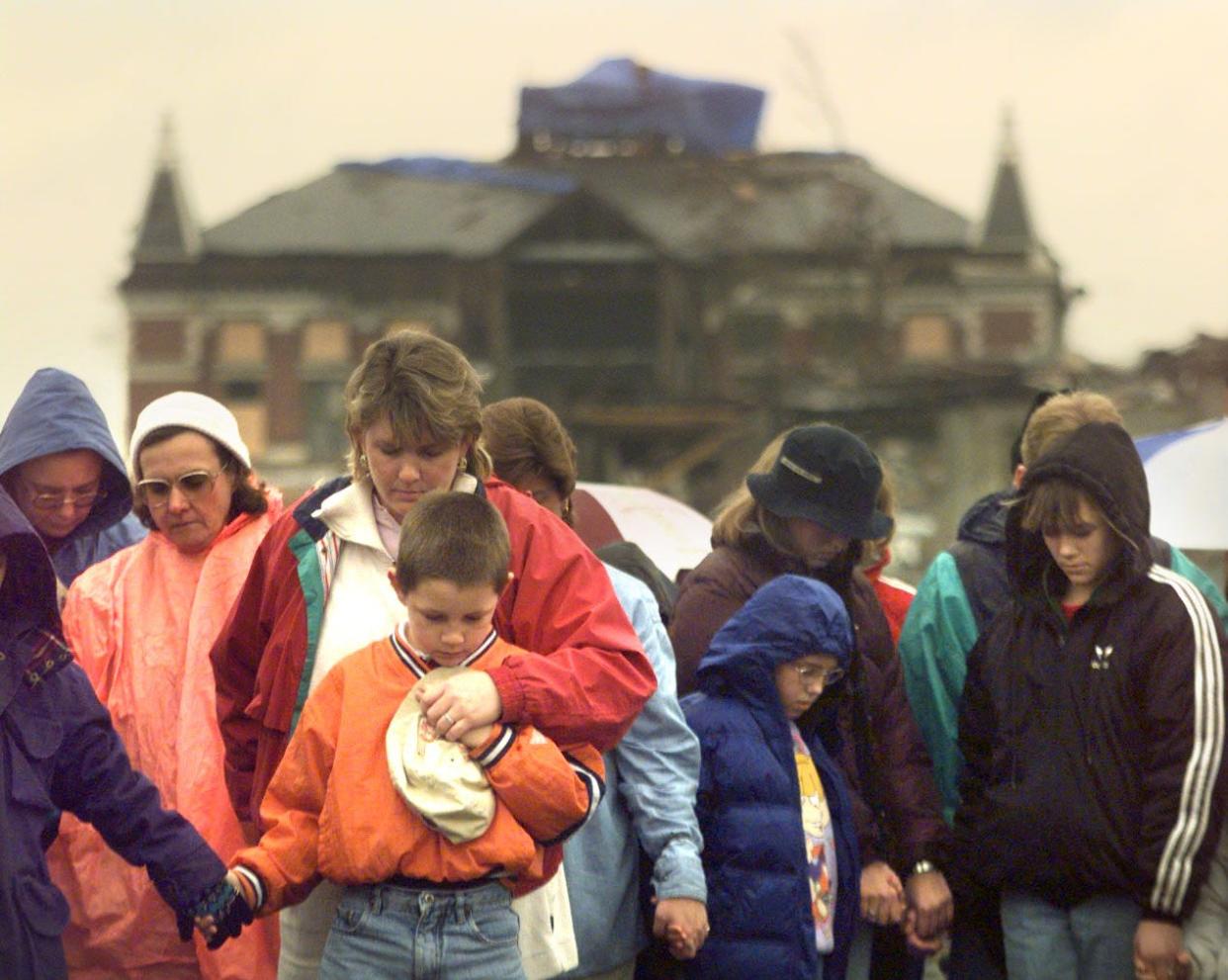 The damaged Montgomery County Courthouse stands in the background during a prayer service that was held after the Jan. 22, 1999, tornado.