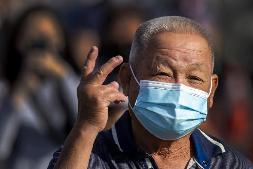 Anaheim, CA - January 13: An Orange County active Phase 1A (critical and healthcare workers) resident shows his optimism while exiting large tents at Orange County's first large-scale vaccination site after receiving the Moderna COVID-19 vaccine in the Toy Story parking lot at the Disneyland Resort in Anaheim Wednesday, Jan. 13, 2021. Orange County supervisors and Orange County Health Care Agency Director Dr. Clayton Chau held a news conference discussing the county's first Super POD (point-of-dispensing) site for COVID-19 vaccine distribution. The vaccinations are at Tier 1A for people who have reservations on a website. The site is able to handle 7,000 immunizations per day. Their goal is to immunize everyone in Orange County who chooses to do so by July 4th. (Allen J. Schaben / Los Angeles Times)