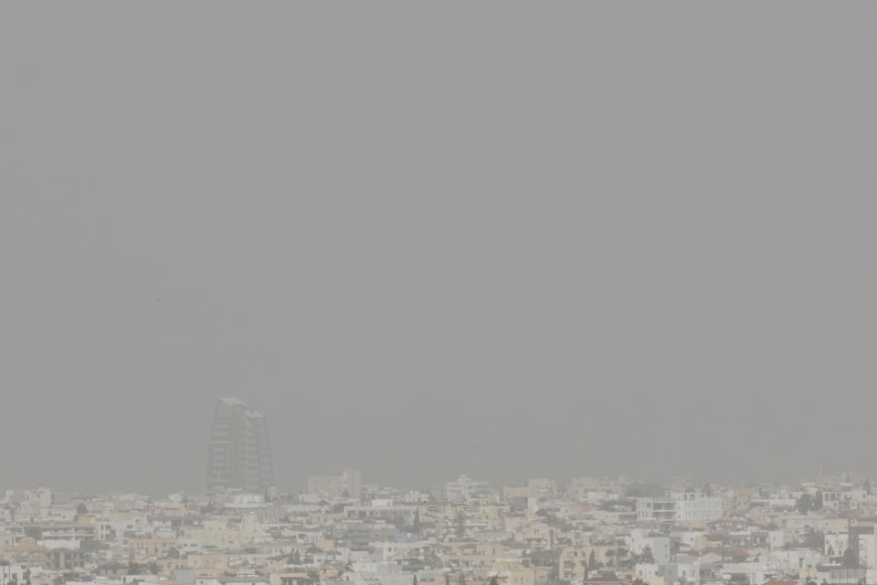 A haze caused by dust covers the capital Nicosia, in the southeast Mediterranean island of Cyprus, on Monday, April 4, 2022. The U.N. health agency says nearly everybody in the world breathes air that doesn't meet its standards for air quality. The World Health Organization is calling for more action reduce fossil-use use that generate pollutants that cause respiratory and blood-flow problems and lead to millions of preventable deaths each year. (AP Photo/Petros Karadjias)