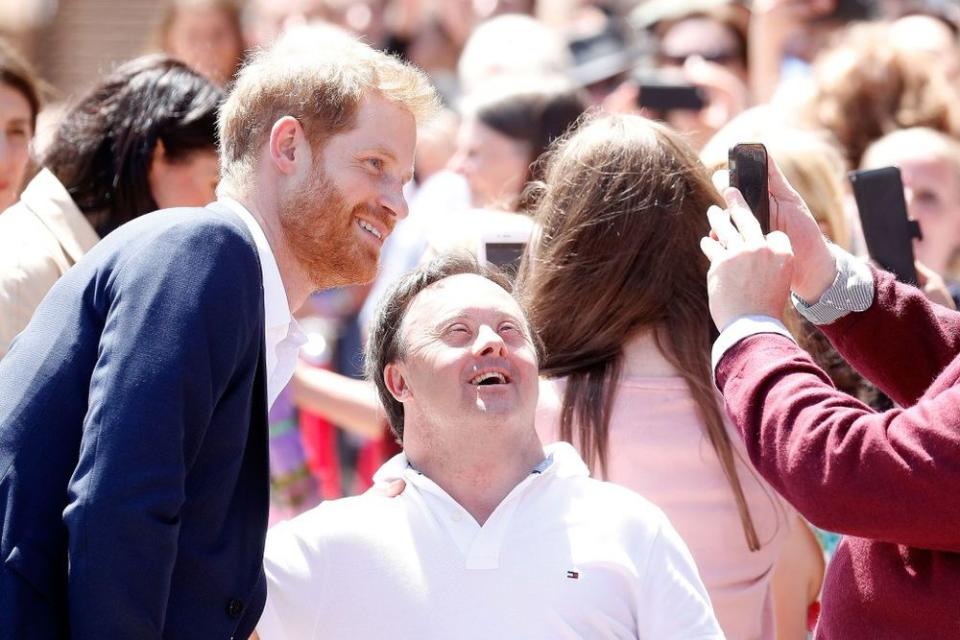 Prince Harry taking a photo with a fan