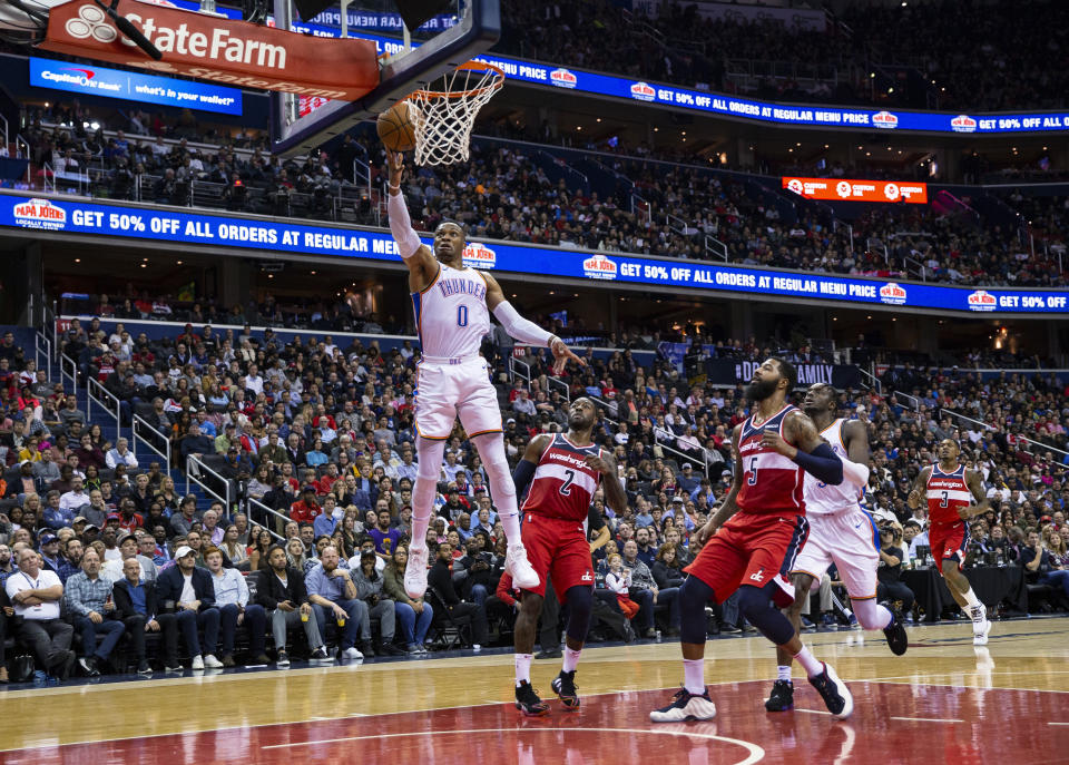 Oklahoma City Thunder guard Russell Westbrook (0) goes for a layup past Washington Wizards guard John Wall (2) and forward Markieff Morris (5) during the first half of an NBA basketball game Friday, Nov. 2, 2018, in Washington. (AP Photo/Al Drago)