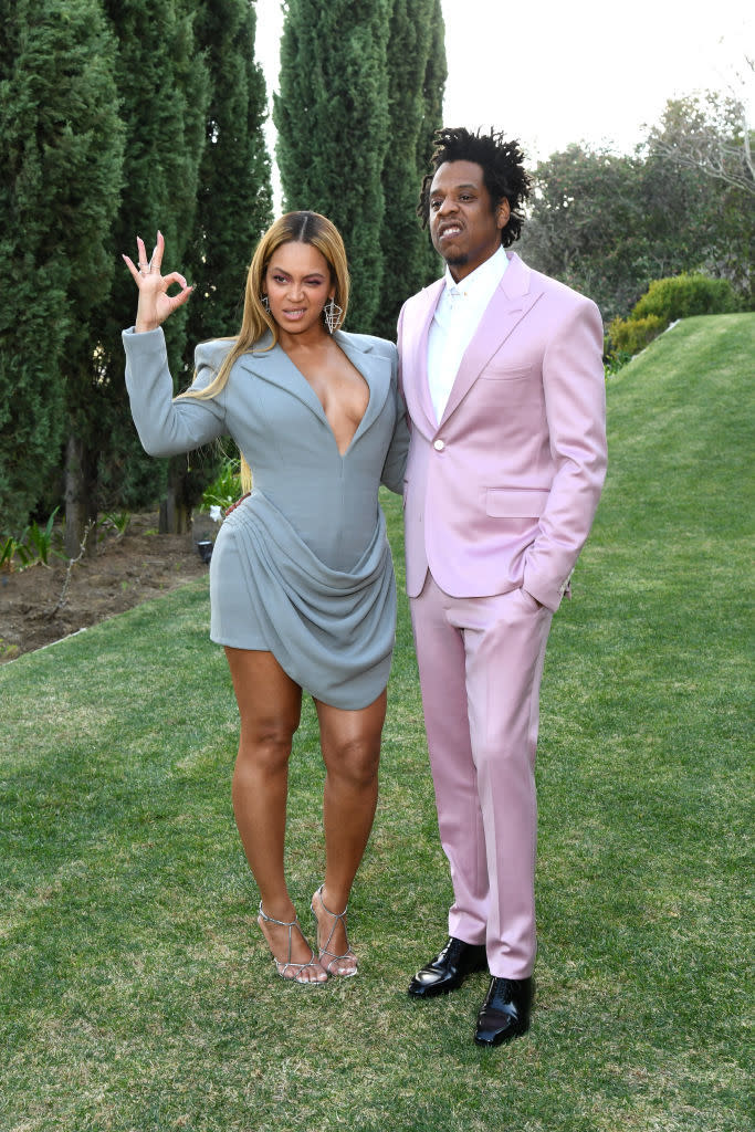 the two posing in the grass in a dress and suit