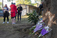 Mourners gather and lay flowers and gifts at the site of a deadly car crash during an impromptu memorial service on Sunday, Oct. 2, 2022, in Lincoln, Neb. Police in Nebraska said a passenger’s cellphone automatically alerted responders after a car hit a tree in a crash that killed all of its young occupants. (Kenneth Ferriera/Lincoln Journal Star via AP)