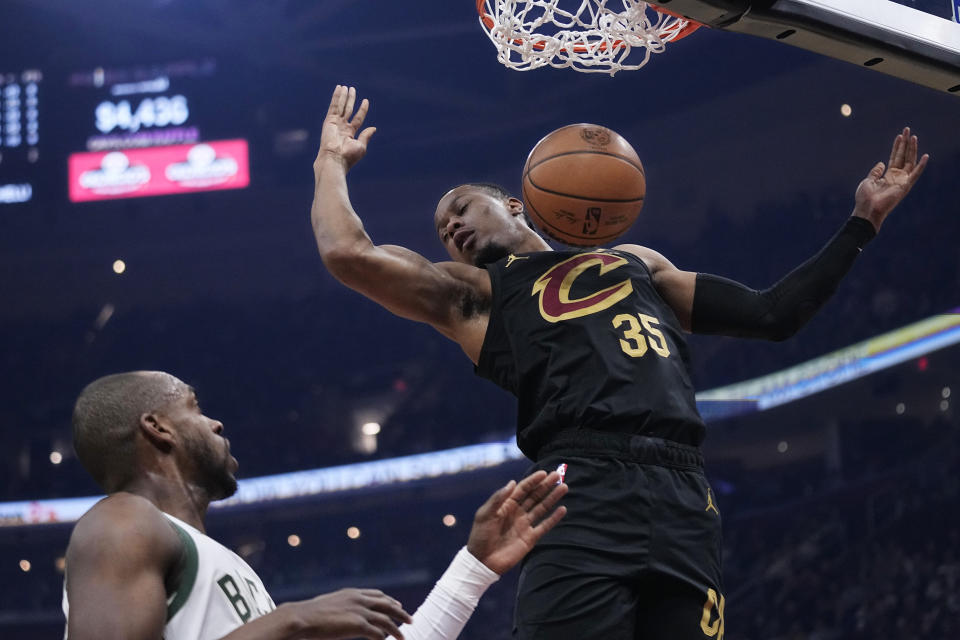 Cleveland Cavaliers forward Isaac Okoro (35) dunks in front of Milwaukee Bucks forward Khris Middleton, left, during the first half of an NBA basketball game Wednesday, Jan. 17, 2024, in Cleveland. (AP Photo/Sue Ogrocki)