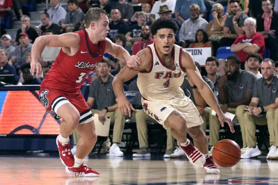 Florida Atlantic guard Bryan Greenlee (4) drives to the basket as Liberty guard Kaden Metheny (3) defends during the second half of an NCAA college basketball game, Thursday, Nov. 30, 2023, in Boca Raton, Fla. (AP Photo/Lynne Sladky)