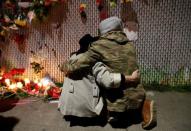 Rachel Saxer (L) embraces friend La Tron at a makeshift memorial near the scene of a fatal warehouse fire in the Fruitvale district of Oakland, California, U.S. December 4, 2016. REUTERS/Stephen Lam