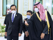 In this photo released by the Saudi Royal Palace, Saudi Crown Prince Mohammed bin Salman, right, welcomes Thai Prime Minister Prayuth Chan-ocha, at the royal palace in Riyadh, Saudi Arabia, Tuesday, Jan. 25, 2022. Thailand's prime minister arrived in Saudi Arabia on Tuesday for the first high-level meeting since relations between the nations soured three decades ago over a sensational jewelry heist that led to a diplomatic row and string of mysterious killings. (Bandar Aljaloud/Saudi Royal Palace via AP)