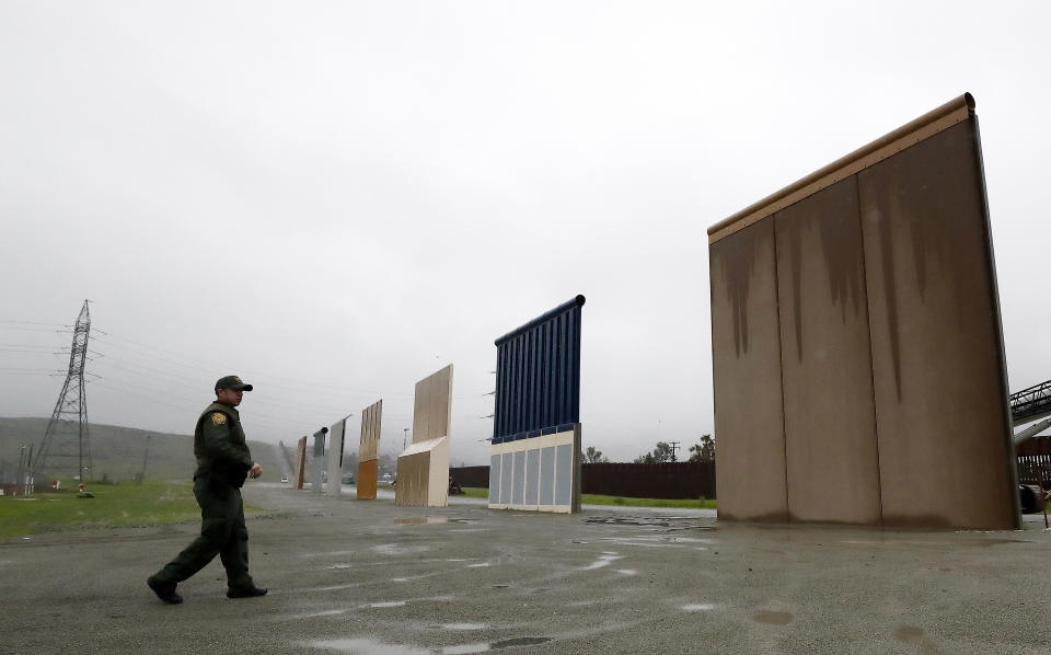 FILE - In this Feb. 5, 2019 file photo, Border Patrol agent Vincent Pirro walks towards prototypes for a border wall in San Diego. An appeals court has upheld a freeze on Pentagon money to build a border wall with Mexico, casting doubt on President Donald Trump's ability to make good on a signature campaign promise before the 2020 election. (AP Photo/Gregory Bull, File)