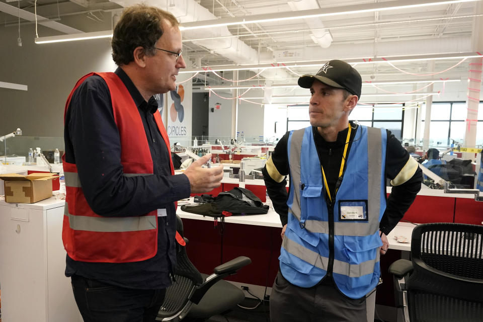 Liam Pederson, deputy general manager for research at Nissan, left, talks with Dan Work, associate professor of civil and environmental engineering at Vanderbilt University on Thursday Nov. 17, 2022, in Nashville, Tenn. Researchers say they have successfully used artificial intelligence in a group of wirelessly connected cars to help ease rush hour traffic on an interstate in Nashville. (AP Photo/Mark Humphrey)