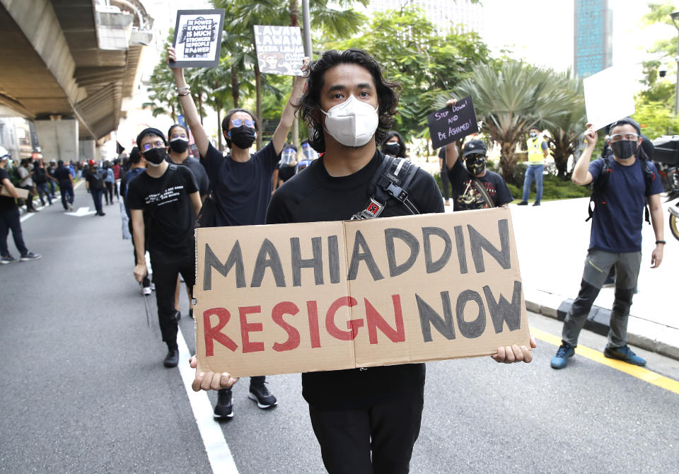 A protester holds placard during a demonstration demanding the prime minister step down near the Independence Square in Kuala Lumpur, Saturday, July 31, 2021. Hundreds of black-clad Malaysian youths have rallied in the city center, demanding Prime Minister Muhyiddin Yassin resign for mismanaging the coronavirus pandemic that has worsened. (AP Photo/FL Wong)