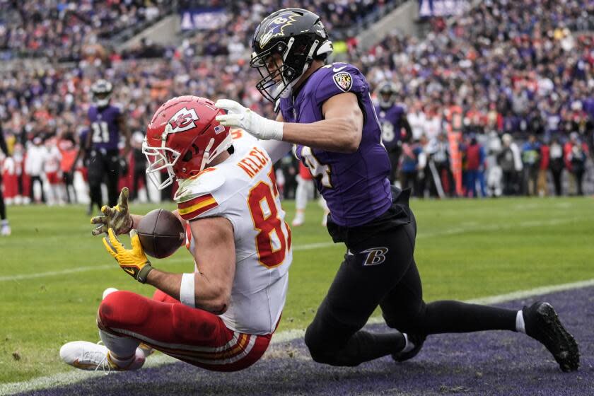 Chiefs tight end Travis Kelce (87) makes a touchdown catch against Baltimore Ravens safety Kyle Hamilton (14).