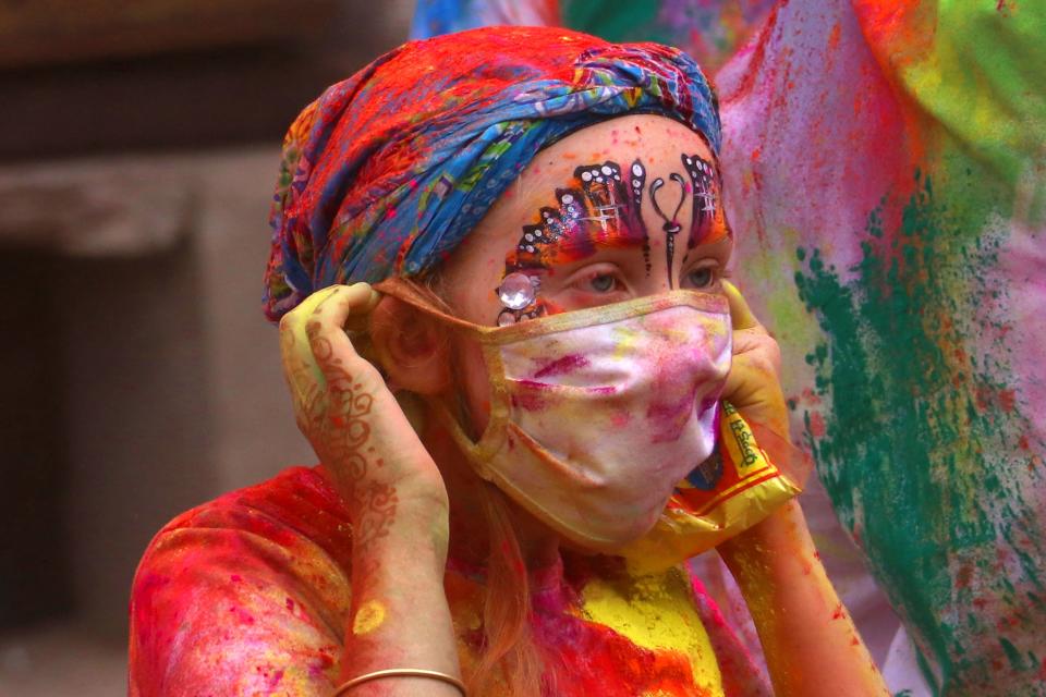 A foreign tourist wears a facemask amid fears of the spread of the COVID-19 coronavirus while celebrating Holi, the spring festival of colours in Pushkar on March 10, 2020. (Photo by Himanshu SHARMA / AFP) (Photo by HIMANSHU SHARMA/AFP via Getty Images)