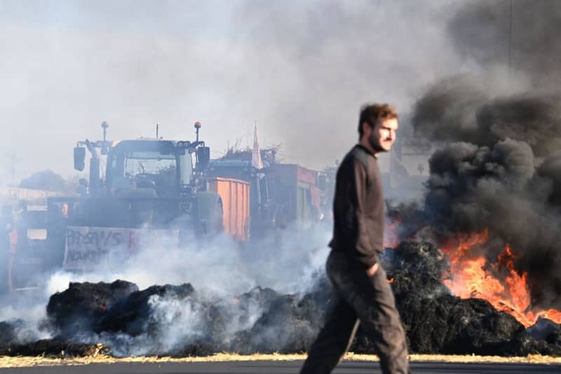 French farmers burn bales of straw while blocking the A9 highway during a demonstration against falling incomes, European environmental regulations and standards that they believe are getting out of hand. Sylvain Thomas/AFP/dpa