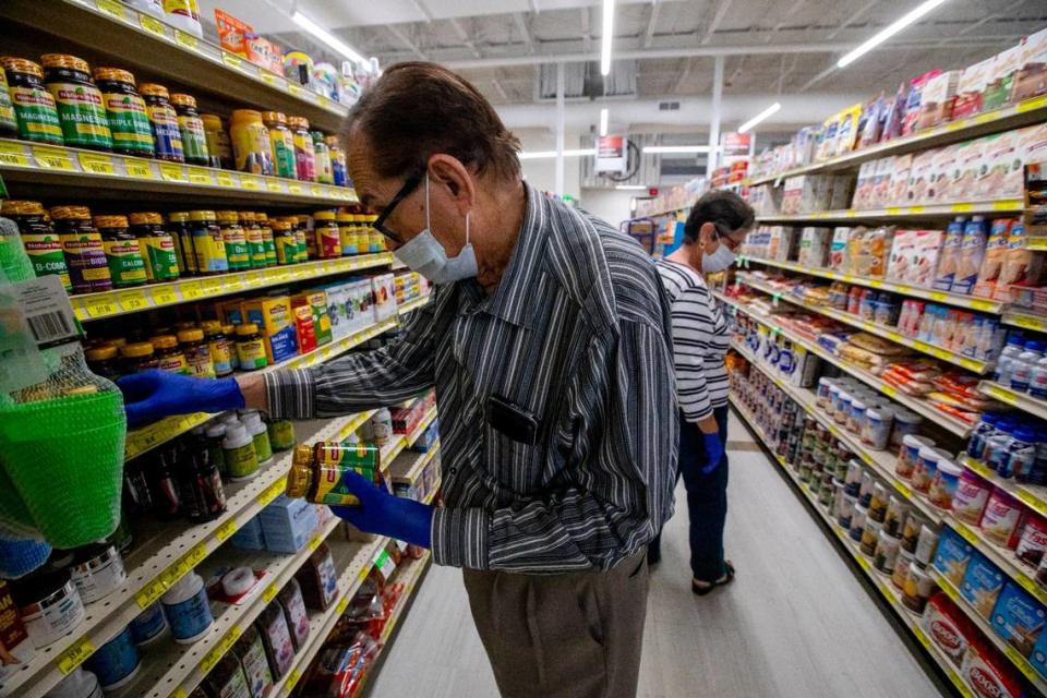 An older couple browses the vitamins at a Sedano’s Supermarket in Hialeah, Florida on Wednesday, April 1, 2020.