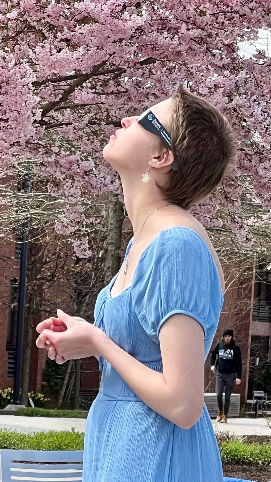 A student at Bucks County Community College in Newtown watches the solar eclipse on campus on Monday, April 8, 2024. The college got 1,500 pairs of glasses to share with the college community.