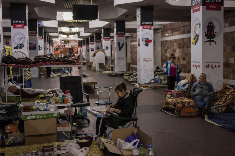 A woman cuts vegetables in the city subway of Kharkiv, in eastern Ukraine, on Thursday, May 19, 2022. Although the bombings in Kharkiv have decreased and the subway is expected to run beginning of next week, still some residents use it as a temporary bomb shelter. (AP Photo/Bernat Armangue)