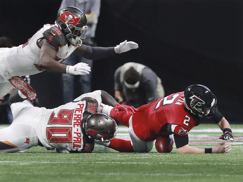 Atlanta Falcons quarterback Matt Ryan, right, fumbles as he is sacked by Tampa Bay Buccaneers linebacker Jason Pierre-Paul, bottom left, during the fourth quarter of an NFL football game Sunday, Nov. 24, 2019, in Atlanta. Buccaneers defensive lineman Ndamukong Suh recovered the fumble for a touchdown. (Curtis Compton/Atlanta Journal-Constitution via AP)