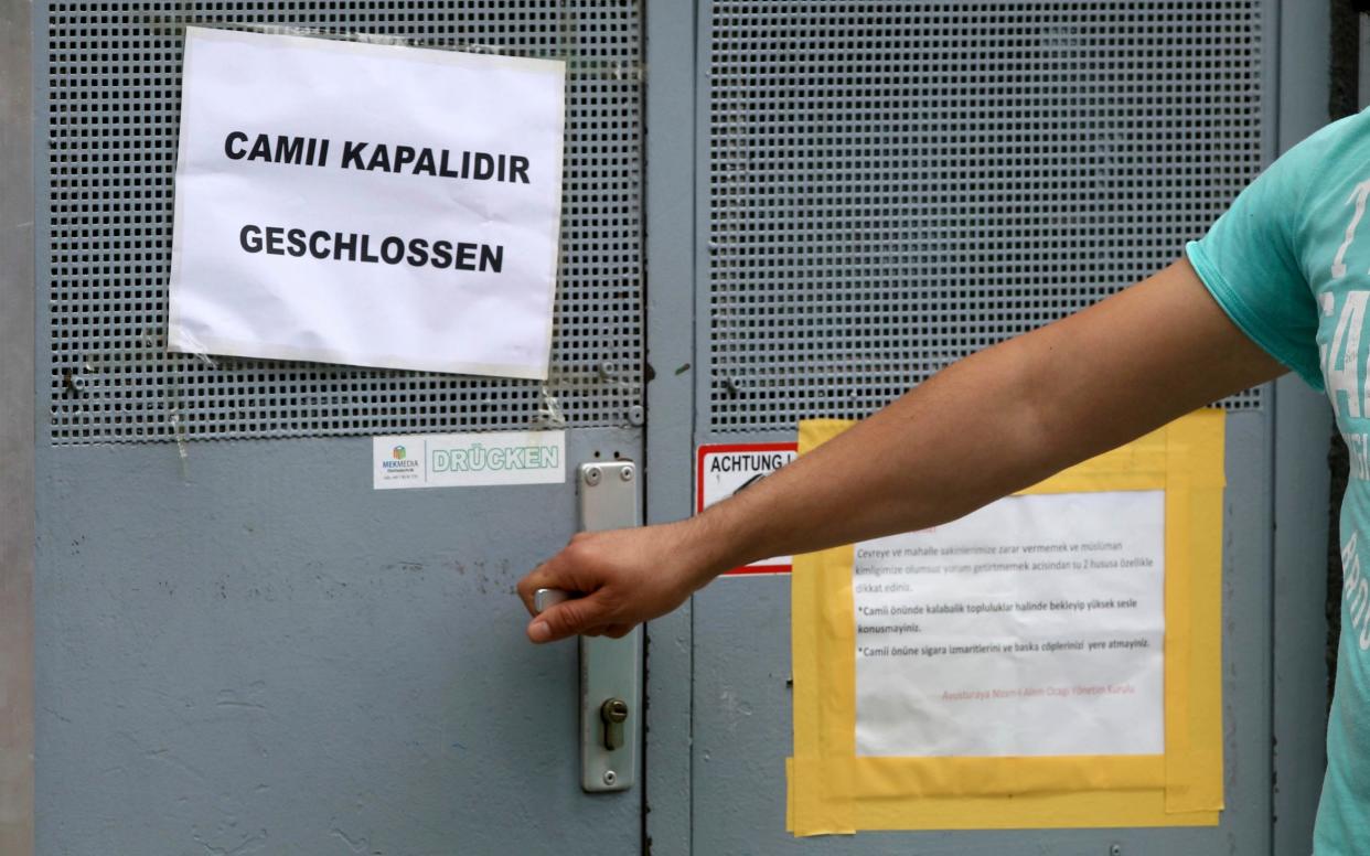 A man tries to open the door, in Vienna, of one of the seven mosques closed by the Austrian authorities in 'political Islam' clampdown - AP