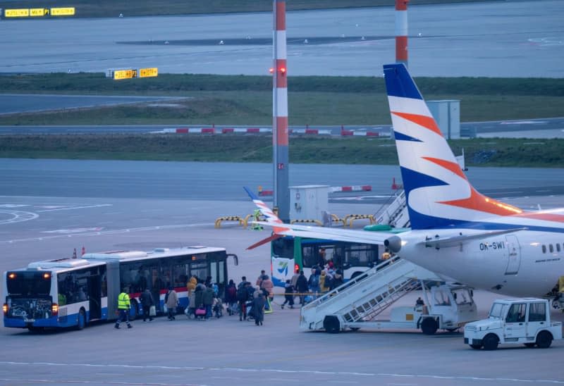Passengers on the Smartwings.com Boeing 737 MAX 8 arriving from Islamabad via Dubai make their way to the buses at the back of the apron at Berlin Brandenburg Airport (BER). A group of Afghans with an acceptance letter for Germany landed in Berlin on Thursday evening. Soeren Stache/dpa
