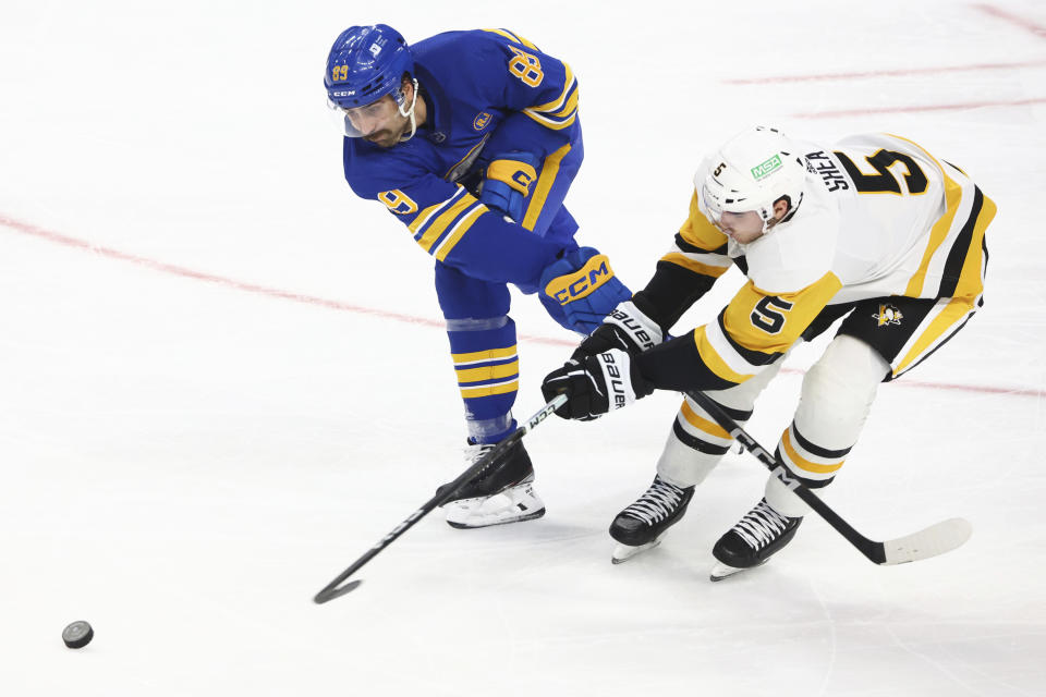 Buffalo Sabres right wing Alex Tuch (89) and Pittsburgh Penguins defenseman Ryan Shea (5) battle for the puck during the third period of an NHL hockey game Friday, Nov. 24, 2023, in Buffalo N.Y. (AP Photo/Jeffrey T. Barnes)
