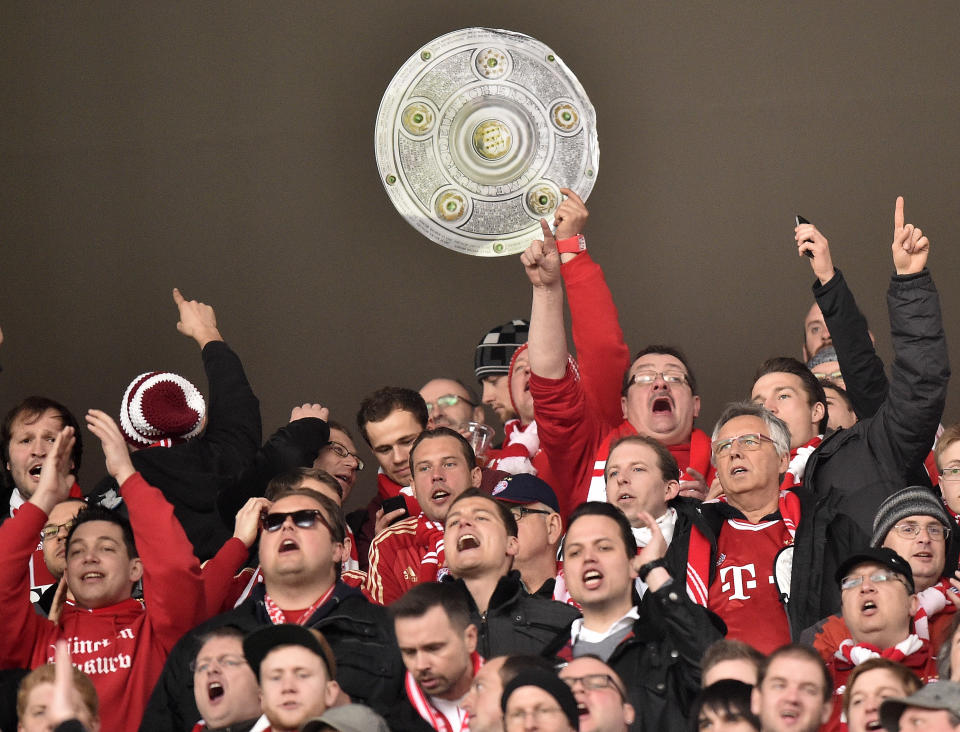 Bayern fans with a trophy celebrate during the German Bundesliga soccer match between FSV Mainz 05 and Bayern Munich in Mainz, Germany, Saturday, March 22, 2014. (AP Photo/Martin Meissner)