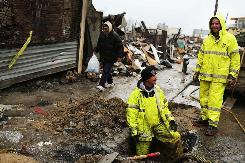 Workers with the Department of Environmental Protection (DEP) work on the sewer system in the heavily damaged Rockaway neighborhood on November 27, 2012 in the Queens borough of New York City.