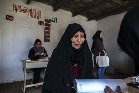 An Afghan woman waits to receive her voter card at a voter registration centre in Kabul March 30, 2014. Afghan presidential elections will be held on April 5. REUTERS/Zohra Bensemra