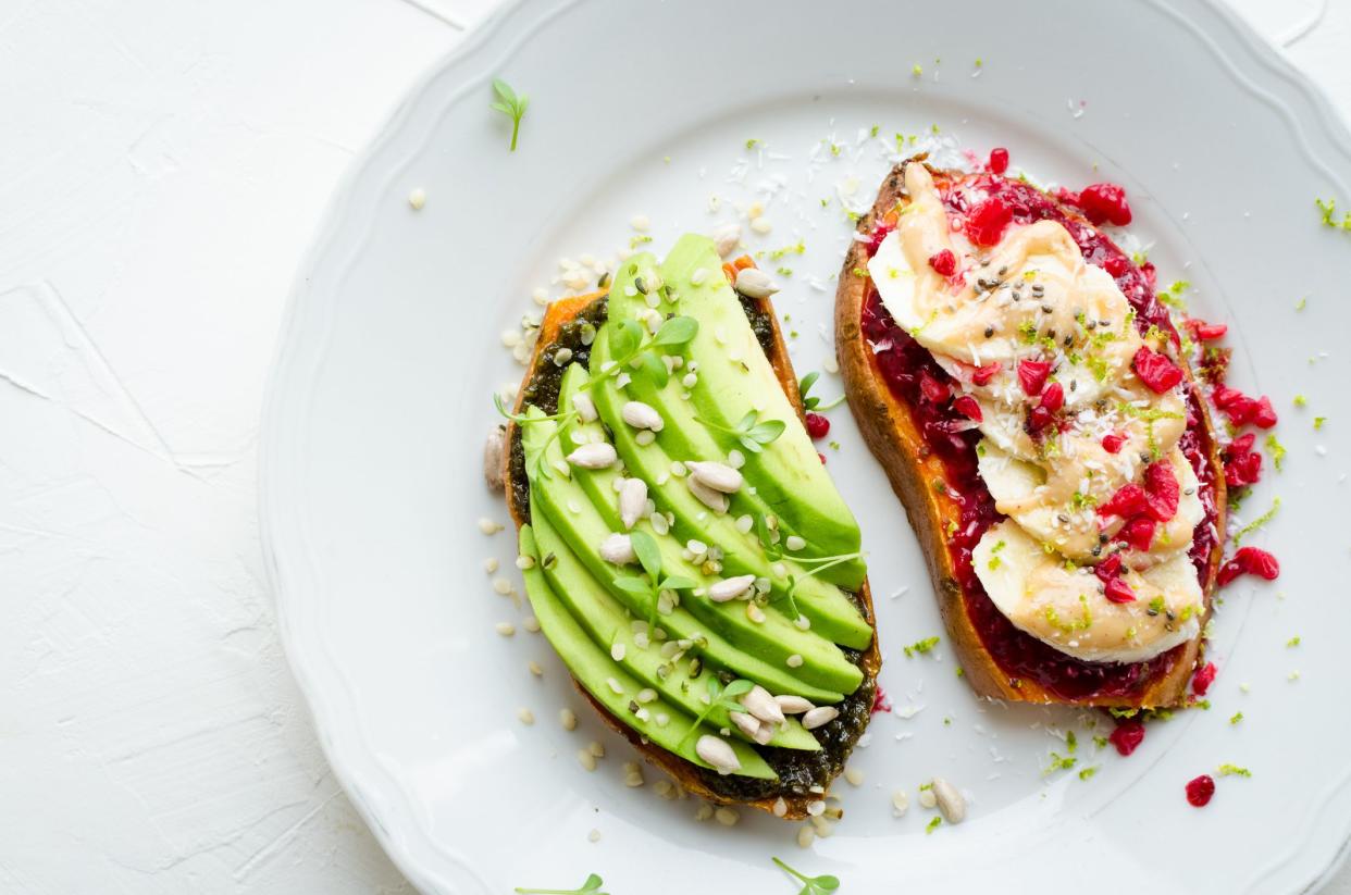 Healthy sandwich on sweet potato for breakfast or snack. One toasts with avocado and other with raspberry chia jam, peanut butter and banana with superfoods. Vegetarian food. Clean eating. Top view.