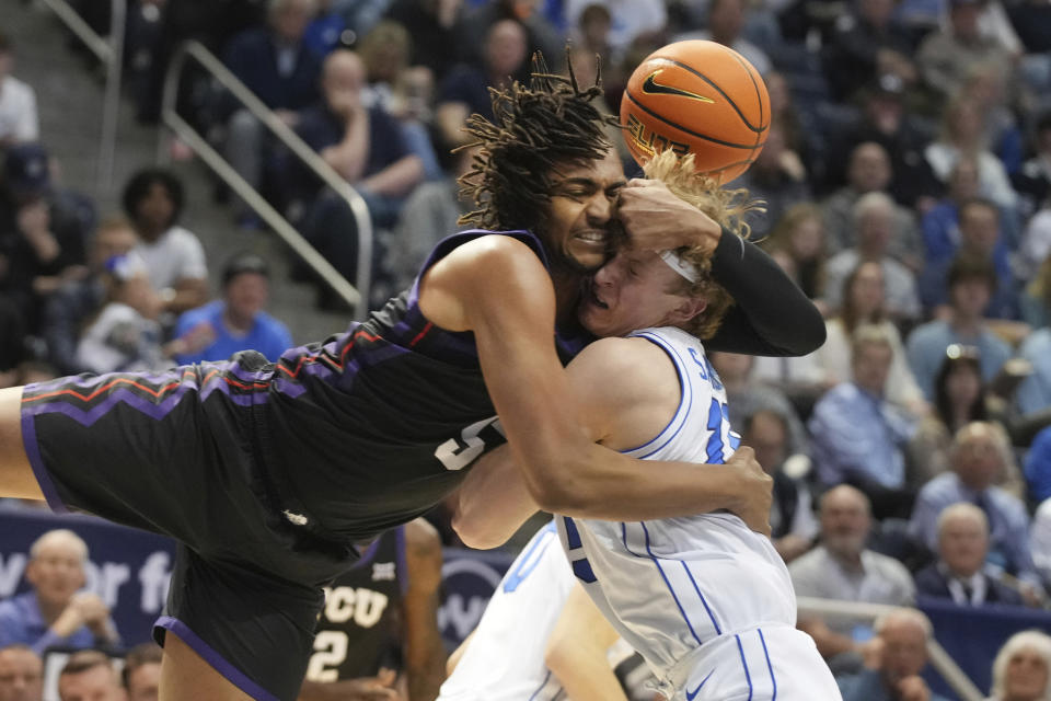TCU forward Chuck O'Bannon Jr. (5) and BYU guard Richie Saunders (15) fight for a loose ball during the first half of an NCAA college basketball game Saturday, March 2, 2024, in Provo, Utah. (AP Photo/George Frey)