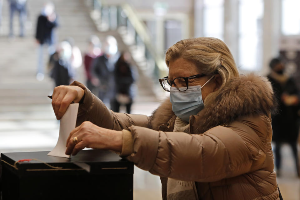 A woman casts her ballot at a polling station in Lisbon, Sunday, Jan. 24, 2021. Portugal holds a presidential election Sunday, choosing a head of state to serve a five-year term. (AP Photo/Armando Franca)