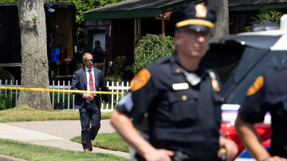 PHOTO: Police officers stand guard as law enforcement searches the home of Rex Heuermann, Saturday, July 15, 2023, in Massapequa Park, N.Y. (Jeenah Moom/AP)