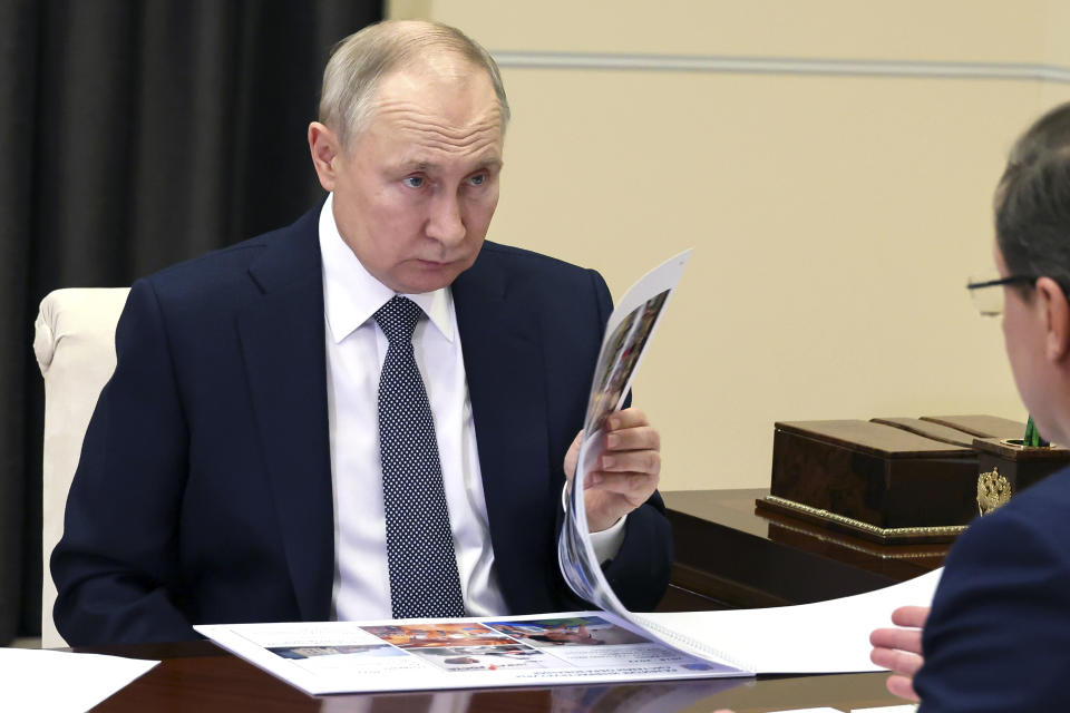 Russian President Vladimir Putin listens to Samara Region Governor Dmitry Azarov, back to a camera, during their meeting at Novo-Ogaryovo state residence, outside Moscow, Russia, Tuesday, March 28, 2023. (Mikhail Klimentyev, Sputnik, Kremlin Pool Photo via AP)