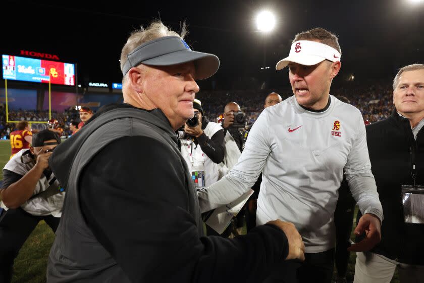 PASADENA, CALIFORNIA - NOVEMBER 19: Head coach Chip Kelly of the UCLA Bruins shakes hands with head coach.