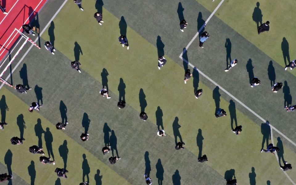 Students maintain social distance as they wait to undergo swab tests in Daegu, South Korea - YONHAP/EPA-EFE/Shutterstock