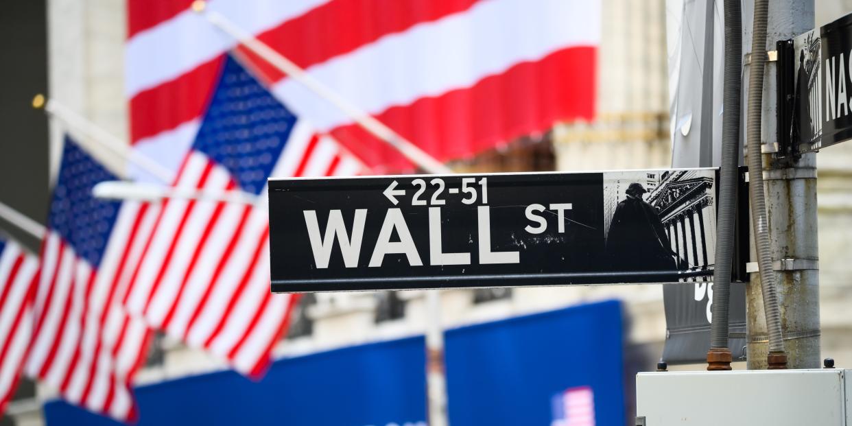A view of the Wall Street street sign with the New York Stock Exchange during the coronavirus pandemic on May 25, 2020 in New York City.