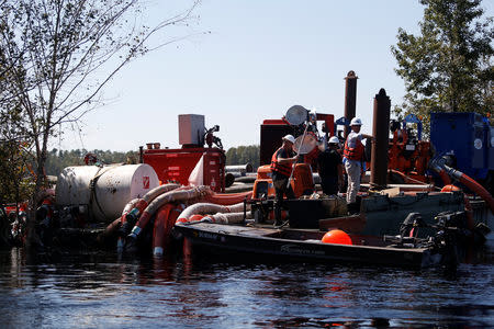 Santee Cooper workers check the water levels around an Aqua Dam and pump system built to keep sediment from a coal ash retention pond from going into the flooded Waccamaw River in the aftermath of Hurricane Florence in Conway, South Carolina, U.S. September 26, 2018. REUTERS/Randall Hill