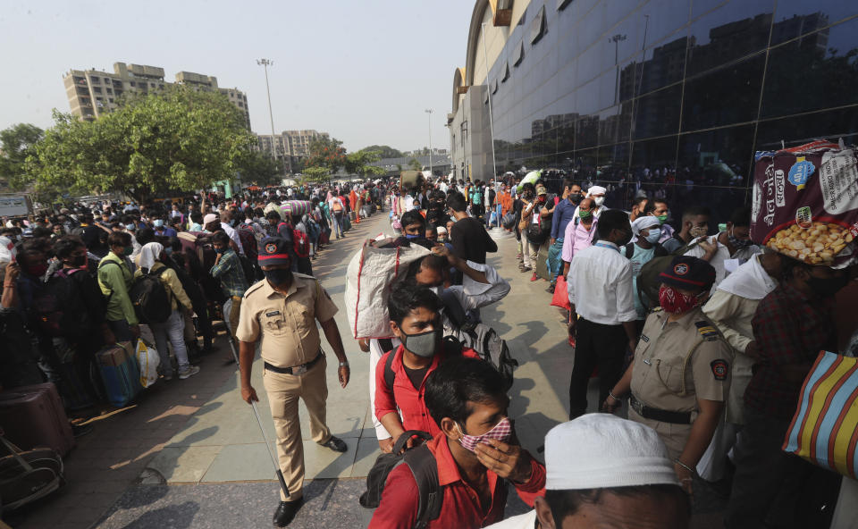 People wearing masks as a precaution against the coronavirus stand in queues to board trains at Lokmanya Tilak Terminus in Mumbai, India, Wednesday, April 14, 2021. Migrant workers are swarming rail stations in India's financial capital Mumbai to go to their home villages as virus-control measures dry up work in the hard-hit region. The government of Maharashtra state imposed lockdown-like curbs on Wednesday for 15 days to check the spread of the virus. It closed most industries, businesses and public places and limited the movement of people, but didn’t stop the bus, train and air services. An exodus ensued, with panicked day laborers hauling backpacks onto overcrowded trains leaving Mumbai, travel that raises fears of infections spreading in rural areas. (AP Photo/Rafiq Maqbool)