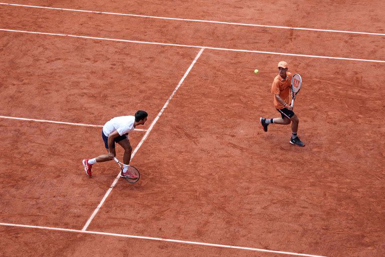 Novak Djokovic y un ball boy como compañero de dobles, durante el Kids Day sabatino en el court central