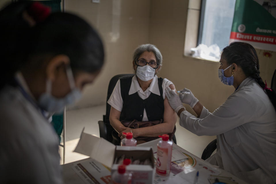 FILE - In this Monday, March 1, 2021, file photo, a woman receives the AstraZeneca COVID-19 vaccine, manufactured by the Serum Institute of India, in Noida, a suburb of New Delhi, India. The world's largest vaccine maker, based in India, will be able to restart exports of AstraZeneca doses by June if new coronavirus infections subside in the country, its chief executive said Tuesday, April 6. But a continued surge could result in more delays because the Serum Institute of India would have to meet domestic needs, Adar Poonawalla warned in an interview with The Associated Press. (AP Photo/Altaf Qadri)