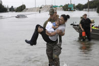 <p>Houston Police SWAT officer Daryl Hudeck carries Catherine Pham and her 13-month-old son Aiden after rescuing them from their home surrounded by floodwaters from Tropical Storm Harvey Sunday, Aug. 27, 2017, in Houston, Texas. (Photo: David J. Phillip/AP) </p>