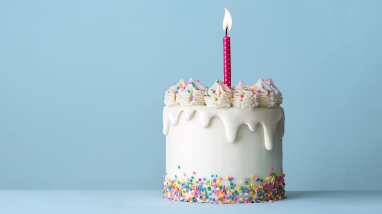 Frosted cake with lit candle