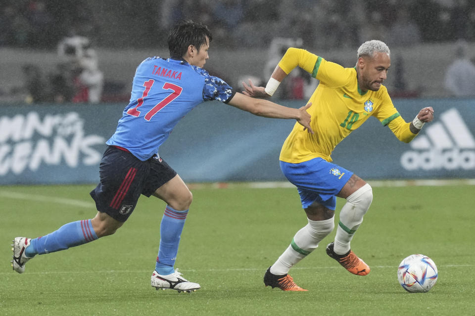 Neymar of Brazil, right, fights for the ball against Ao Tanaka of Japan during a friendly match at the National Stadium in Tokyo Monday, June 6, 2022. (AP Photo/Eugene Hoshiko)