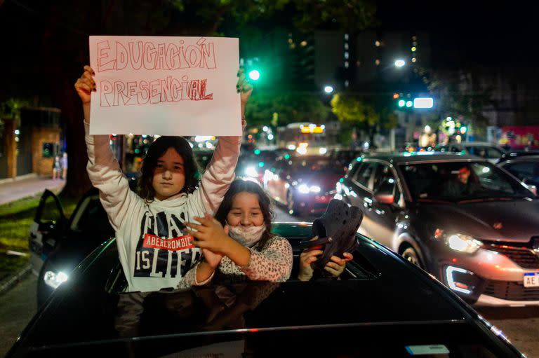 Durante la protesta en Olivos contra el cierre de escuelas, dos niñas sostienen un cartel que dice: "Educación presencial". Foto: TOMAS CUESTA - LA NACIÓN